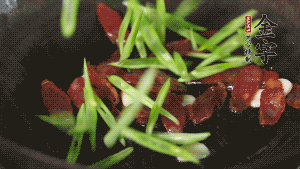 先后下香腸片、四季豆絲均勻翻炒，加適量清水燜煮一下。