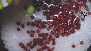 將炒好的食材和大米、紅豆一起放進(jìn)電飯鍋煮。