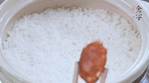 煮開(kāi)后轉(zhuǎn)小火，當(dāng)米飯出現(xiàn)小孔時(shí)，鋪上金字麻辣香腸。