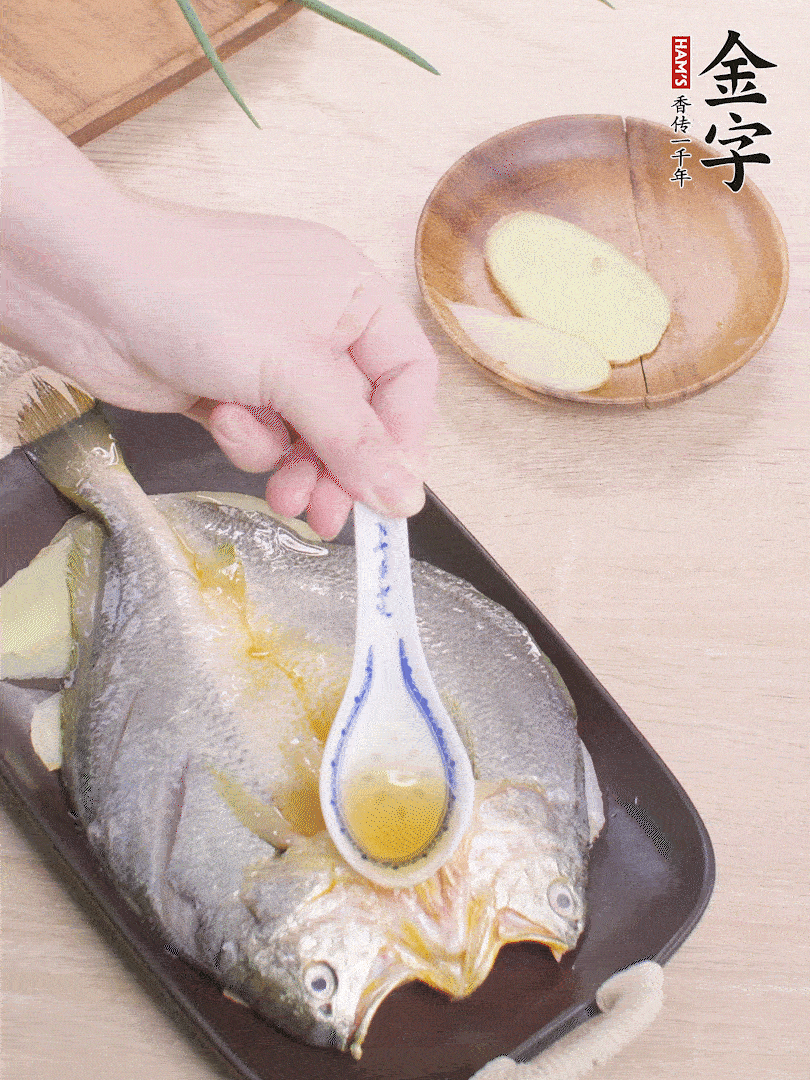 盤(pán)底鋪姜片，放黃魚(yú)，淋2勺料酒。