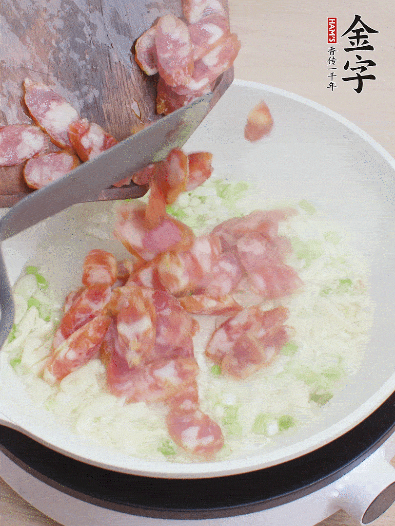 油5成熱，蒜末、蔥白爆香，下香腸炒出香味。