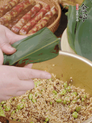 粽葉往下折，完全蓋住，兩側(cè)捏緊。