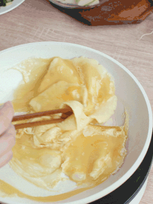 油6成熱時，下雞蛋液，邊緣凝固時翻拌成塊狀。