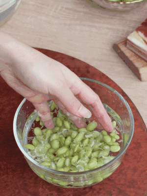 青豆剝殼，搓去外衣。