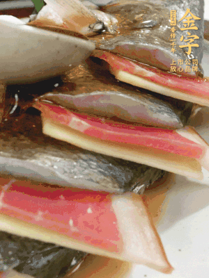 魚肚中塞蔥結(jié)、火腿片，魚身上碼放姜片、火腿片，倒入混合的料汁。