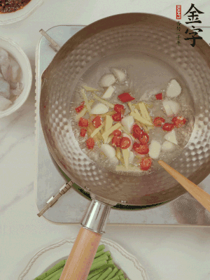 油7成熱時，下大蒜粒、姜絲、小米辣煸香。