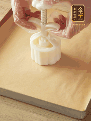 取一個(gè)面團(tuán)，捏扁，中間厚，四周薄?；⒖谕贤?，直到收口，把餅胚放入模具里，壓2-3下