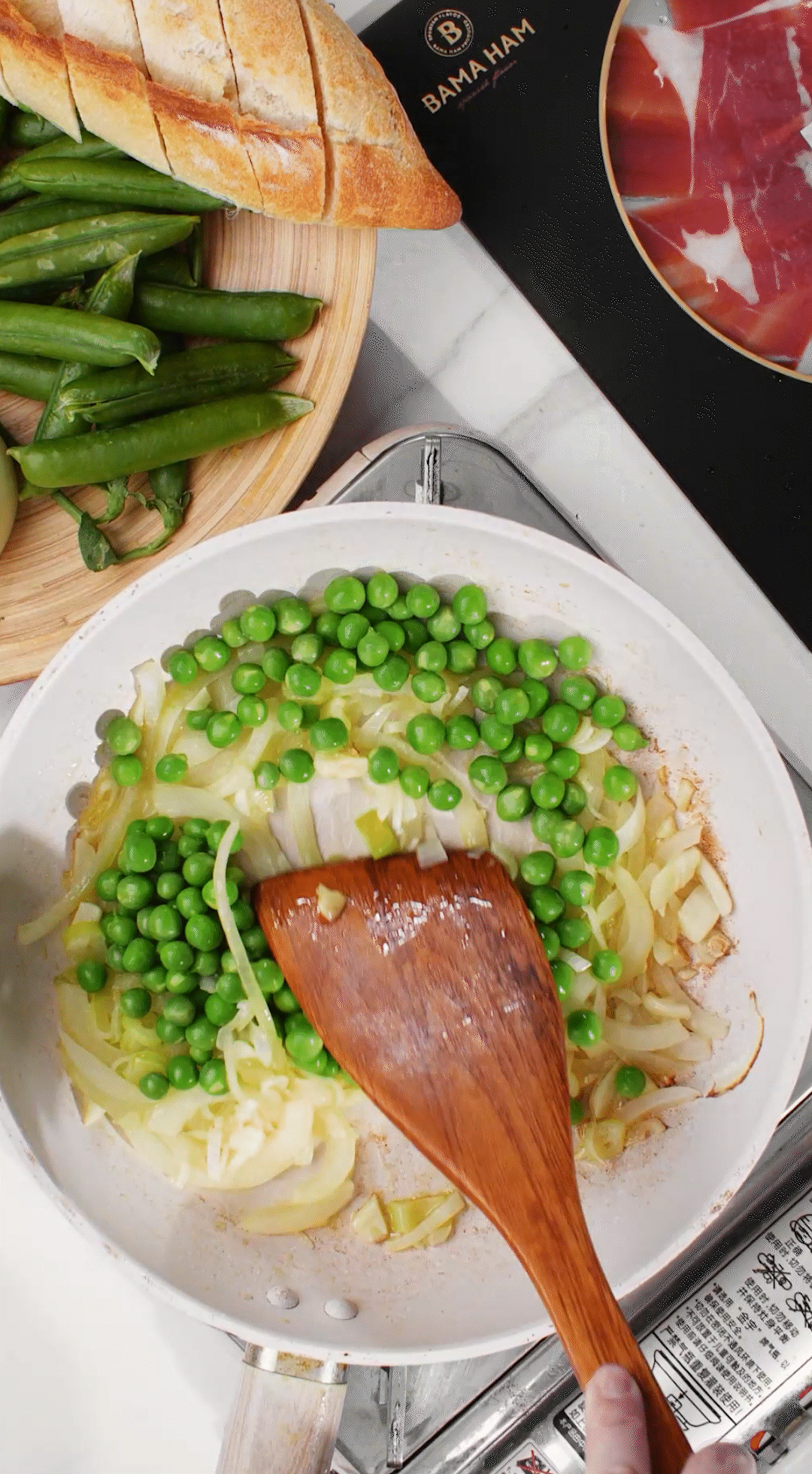 鍋中放入黃油融化，加入洋蔥絲、大蔥蔥白絲、蒜末翻炒變軟出香味。加入剛剛汆燙冰鎮(zhèn)后的豌豆，取出一點(diǎn)點(diǎn)待會擺盤裝飾用。加一點(diǎn)鹽 (和黑胡椒) 調(diào)味。