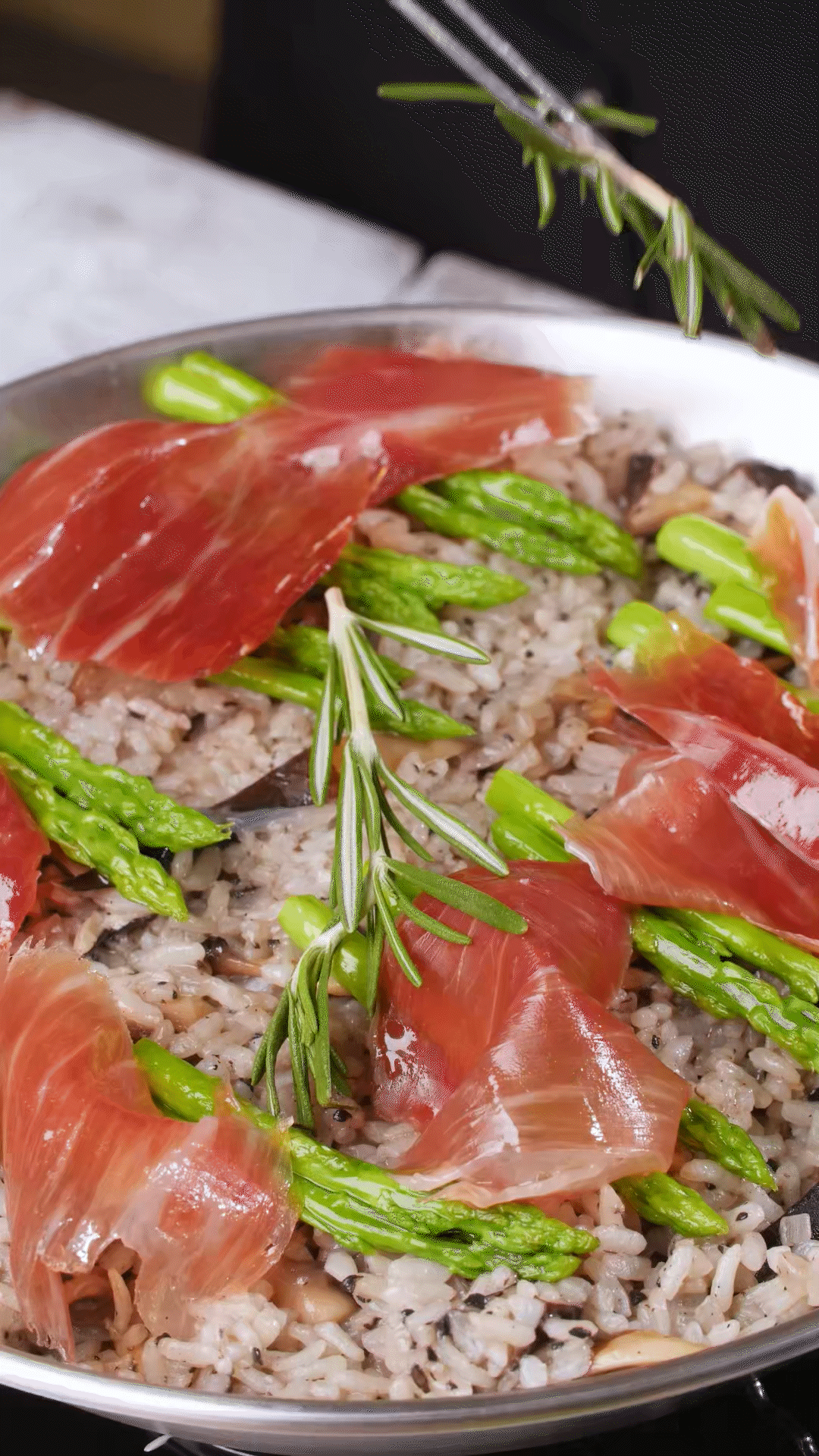 放上巴瑪火腿和蘆筍、點(diǎn)綴迷迭香、三色堇