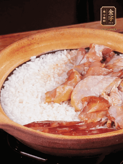 煮到椰子水微微收干轉(zhuǎn)小火，快速均勻鋪上雞肉、金字香腸