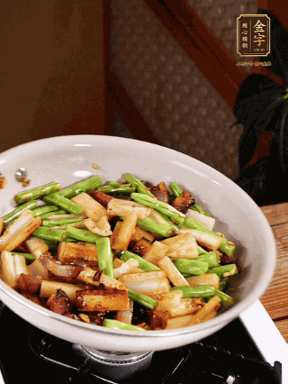 油熱下蒜末、干辣椒、醬肉煸炒出香味，依次下藕條、豆角翻炒均勻